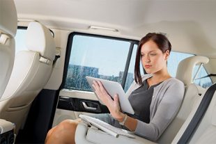 Frau mit Tablet im Auto