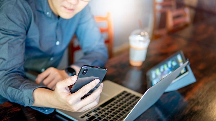 Mann mit Laptop und Smartphone