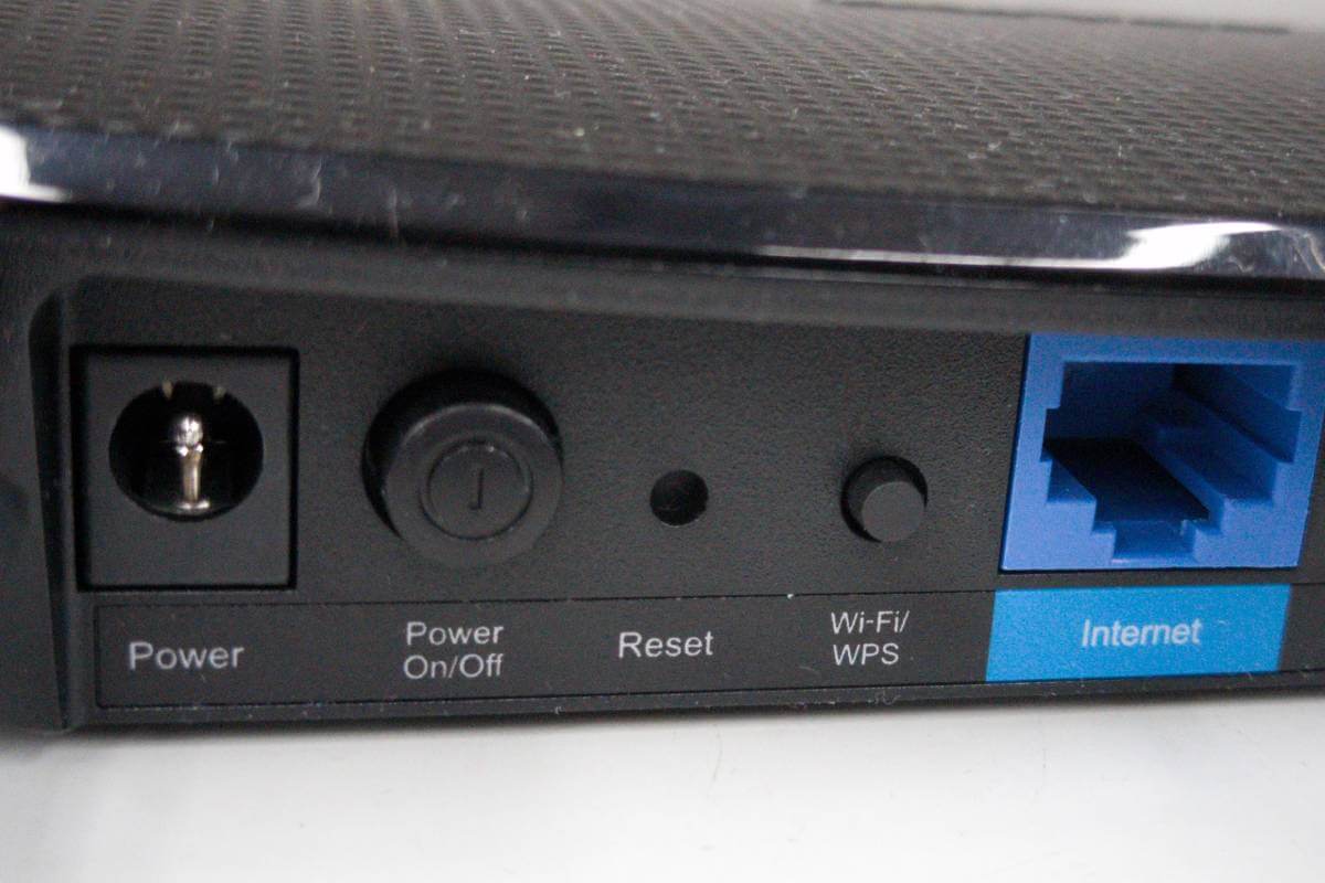 Rückseite eines TP-Link Routers mit beschrifteter Reset-Taste zwischen Power-Schalter und WPS-Taste